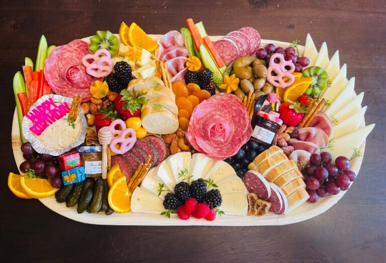 Assorted artisan cheeses with grapes, berries, crackers and fresh herbs