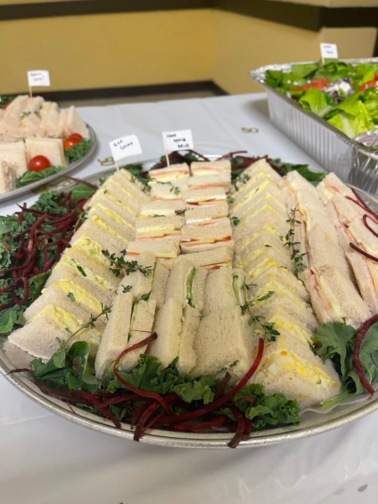PlatterAssorted sandwiches arranged with fruit, vegetables and savory snacks
