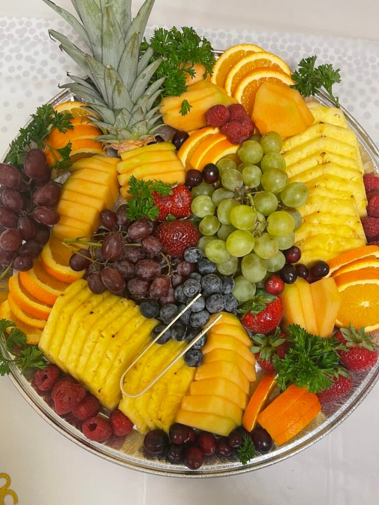 Fresh grapes, berries and sliced cheeses arranged on a grazing board